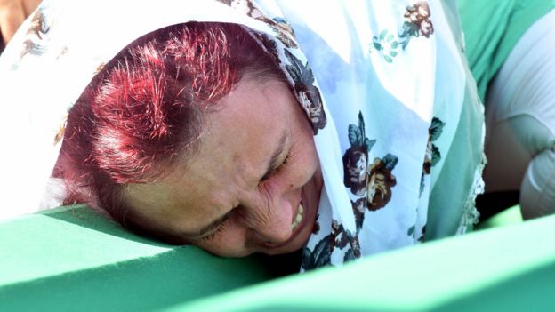 Una mujer llora desconsolada sobre el féretro que lleva los restos de un familiar asesinado en Srebrenica