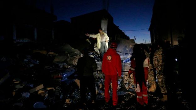 Bomberos sobre escombros