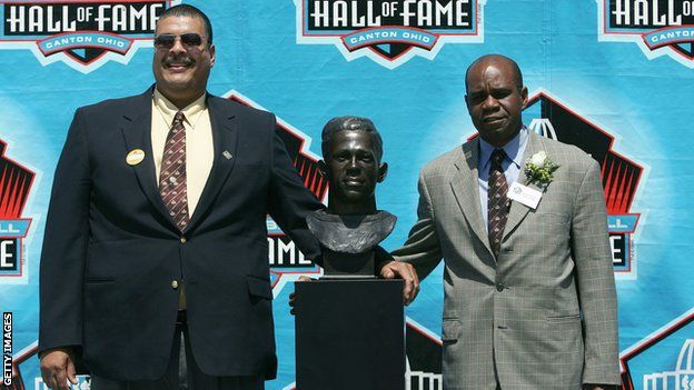 Grandchildren Fritz III (left) and Steven Towns (right) pose with a bust of Pollard at his 2005 Hall of Fame induction