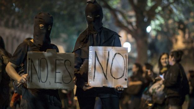 Encapuchados con carteles de "No es No"