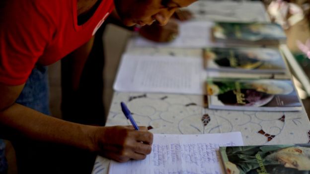 Una mujer firma el juramento al 