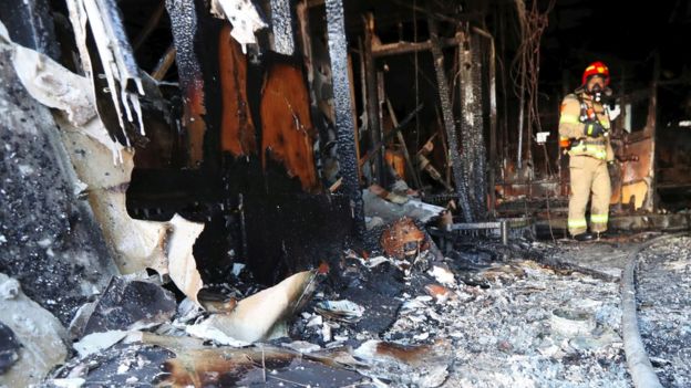 A firefighter searches the debris after a fire at a hospital building in Miryang