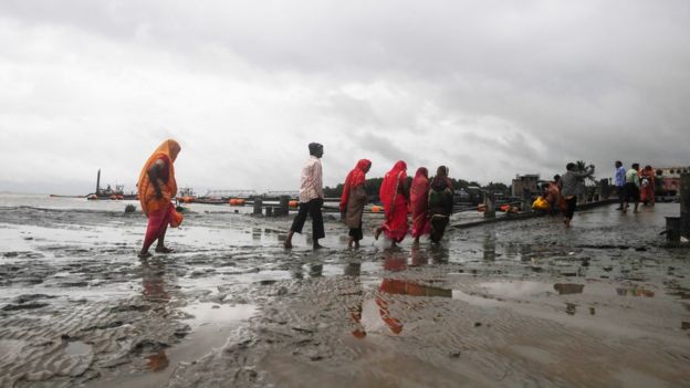Hindu pilgrims walk back from the dock after a ferry service to Sagar Island was suspended due to Cyclone Bulbul