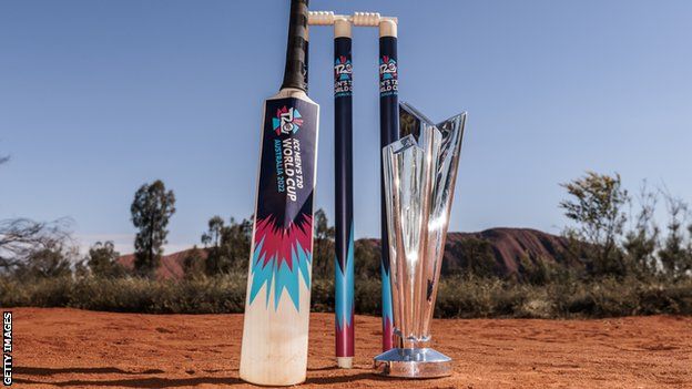 The T20 World Cup trophy next to some stumps and a cricket bat in the Australian outback