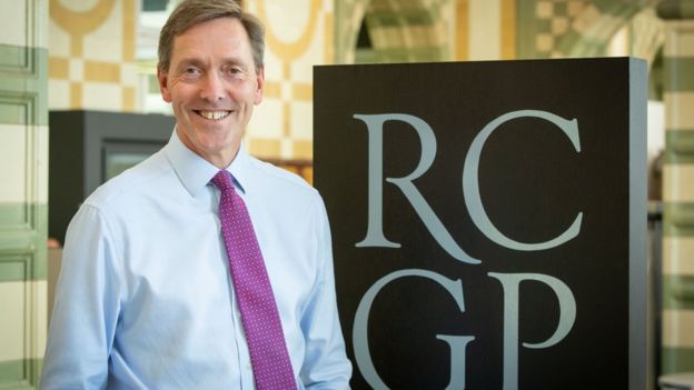 Prof Martin Marshall stands next to a logo for the Royal College of GPs