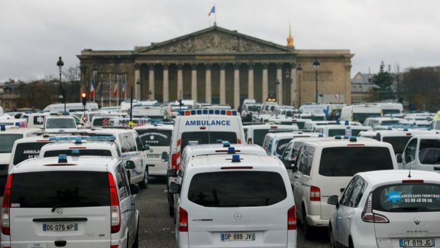 Motoristas de ambulância se juntaram ao protesto e bloquearam o trânsito no entorno da Assembleia Nacional de Paris (ao fundo)
