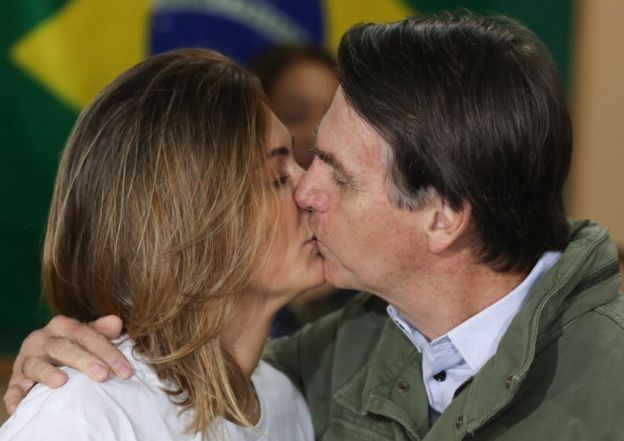Michelle y Jair Bolsonaro se besan después de votar.