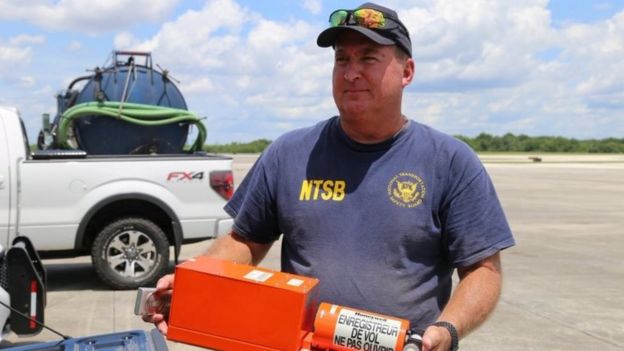 A National Transportation Safety Board (NTSB) investigator is seen with flight data recorder