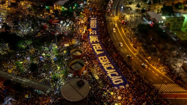 Vista aérea de manifestação em São Paulo em prol das universidades públicas; do alto, lê-se faixa: 'O Brasil se une pela educação'