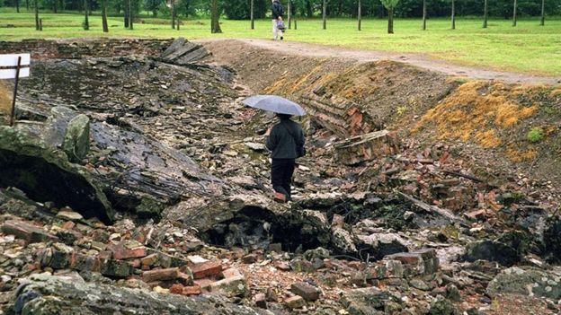 Un visitante camina entre las ruinas de una de las cámaras de gas del campo de exterminio de Auschwitz-Birkenau