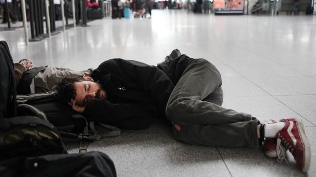 chico durmiendo en el suelo del aeropuerto