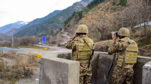 Soldados paquistaníes observan el movimiento de tropas indias con binoculares en el puesto de Chakothi