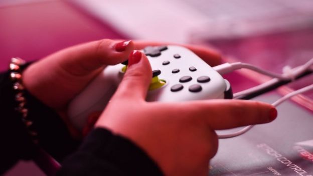 Hands playing a games console
