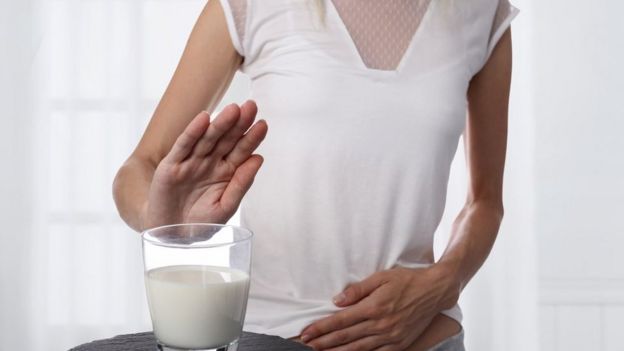 Una persona rechazando un vaso de leche