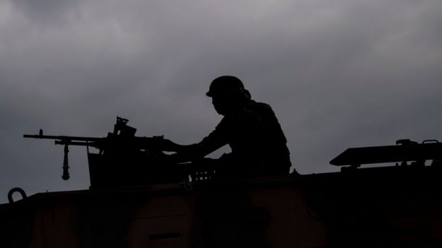 Sombra de um soldado em cima de veículo militar