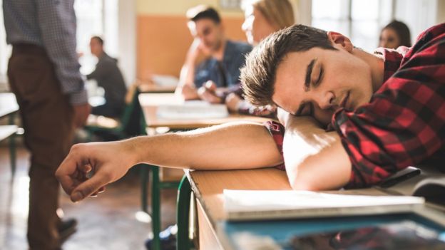 Estudiante dormido en el aula.