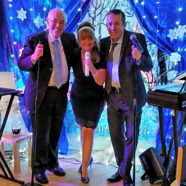 O reverendo David Walford, Rachel Burns e o cantor Row Matthews em uma performance em Park Hall, no Natal de 2014