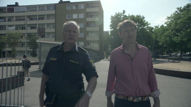 Glen Sjogren, do alto escalão da polícia sueca, caminha ao lado do repórter da BBC, Gabriel Gatehouse, em entrevista sobre os índices de criminalidade na cidade de Malmo