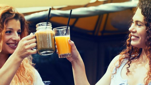 Dos mujeres brindan con jugos.