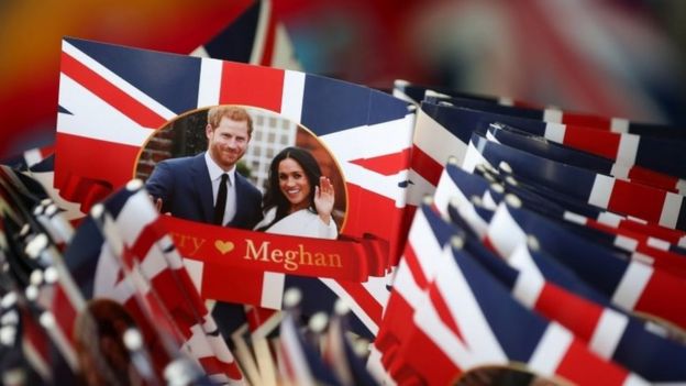 Banderas con la imagend e Meghan Markle y el príncipe Harry.