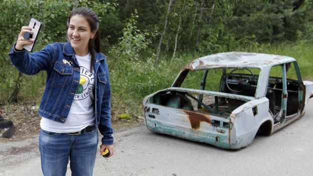 Una turista posa en la zona de exclusión de Chernóbil en la ciudad abandonada de Pripyat