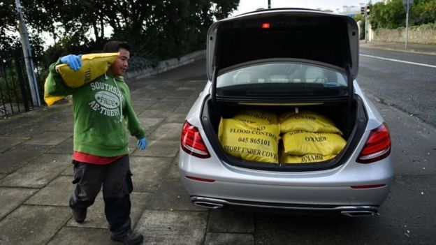 A man loading a car with sandbags on the outskirts of Dublin