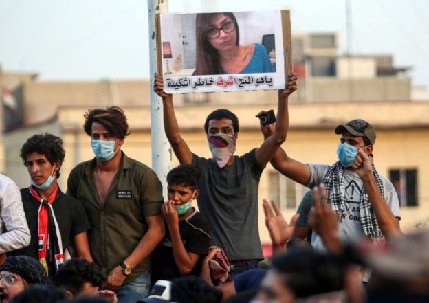 Hombres sostienen un cartel con la foto de Mia Khalifa