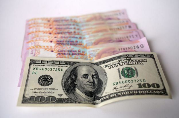 Billete de 100 dólares y de 100 pesos argentinos