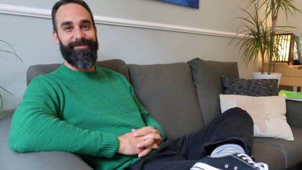 Rafael GarcÃa is photographed on a couch in a living room