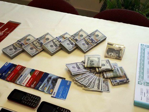 Pilhas de dólares, cartões de crédito, celulares e identidades falsas confiscados