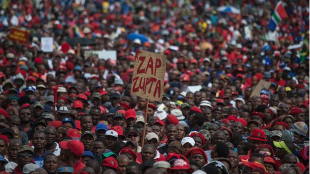 A protester holds a placard reading "Zap Zupta", refering to Zuma and the Gupta Family, as South African demonstrators from various political and civil society groups march through the capital Pretoria calling for President Jacob Zuma to resign on April 12, 2017.
