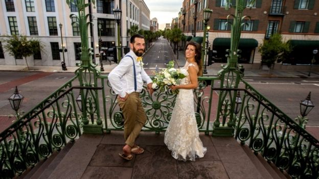 A newlywed couple stand in the deserted streets of Charleston, South Carolina