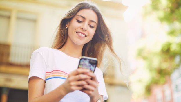 Una joven mirando el celular.