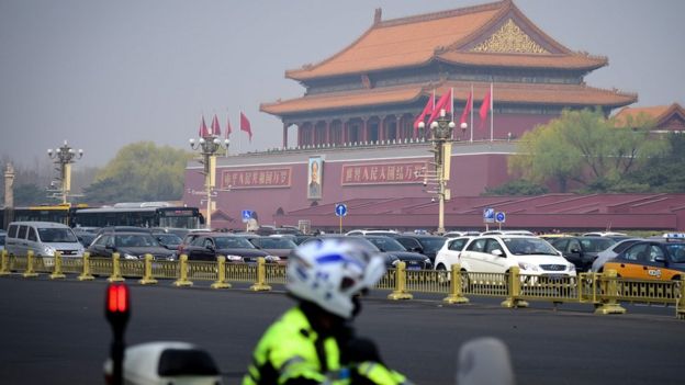A police officer rides his motorcycle patrolling near Tiananmen Square in Beijing on March 27, 2018.