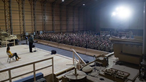 US President Donald Trump speaks to members of the US military as First Lady Melania Trump looks on during an unannounced trip to Al Asad Air Base in Iraq, December 26, 2018