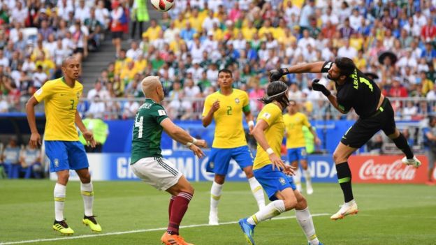 Alisson despeja el centro de Guardado en el primer minuto de partido.