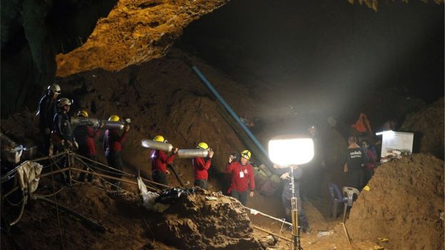 rescuers carry oxygen tanks