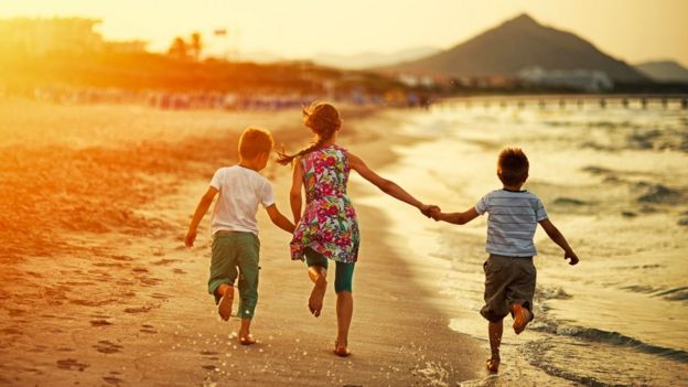 Niños corriendo en una playa española al atardecer