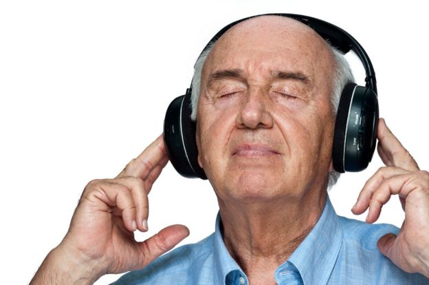 Un hombre semicalvo escucha música