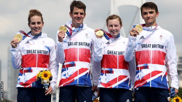 Jessica Learmonth, Jonny Brownlee, Georgia Taylor-Brown and Alex Yee of Team Great Britain pose with their mixed relay triathlon gold medals on the podium at the Tokyo 2020 Olympic Games