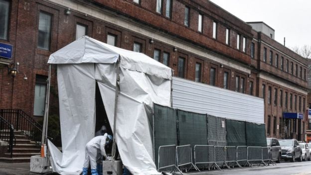 A medical worker approaches a refrigerator truck being used as a morgue outside of Brooklyn Hospital Center amid the coronavirus pandemic on April 3, 2020 in New York City