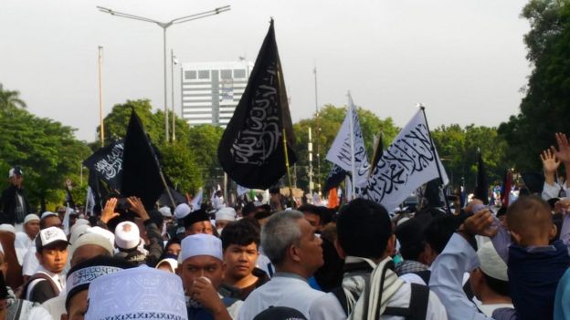 Peserta Reuni 212 memadati kawasan Monas sambil mengangkat bendera-bendera bertuliskan kalimat Tauhid.
