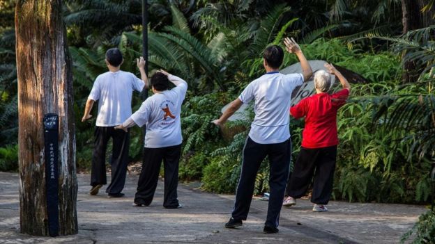 أشخاص يمارسون الرياضة في متنزه في سنغافورة
