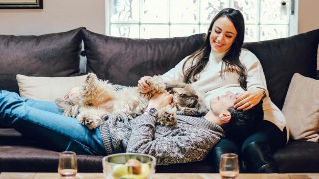 Pareja en un sofá con un perro.