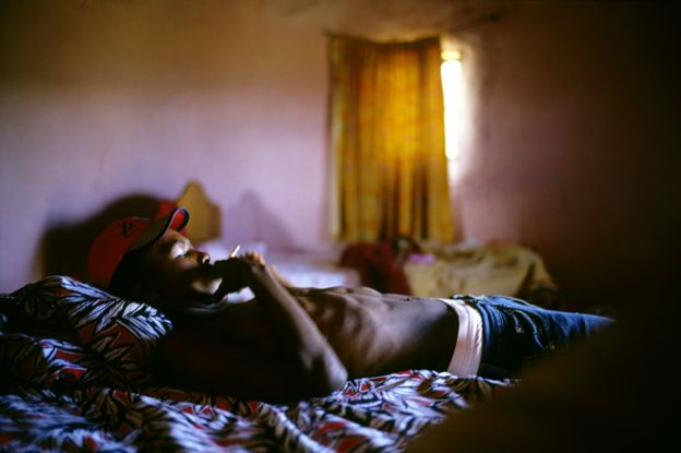 Un joven descansando en una cama en Lady Frere, antes de una ceremonia de ingreso a la adultez.