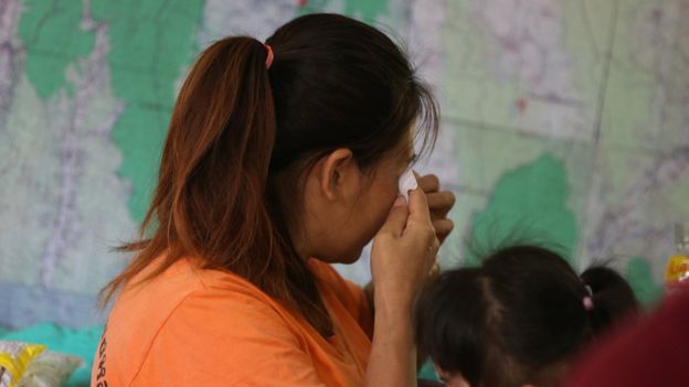 A relative of the 12 boys and their soccer coach trapped in the Tham Luang cave complex cries while listening to a news conference about the death of a Thai rescue diver