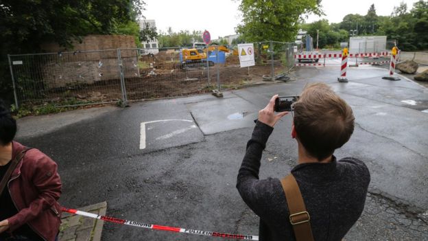 man with phone taking picture of construction site