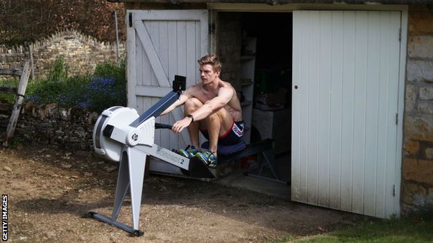 Tom George on a rowing machine outside his parents' garage
