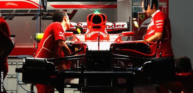 The Ferrari team work in the garage at night