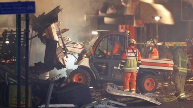 An excavator is used to search through the debris